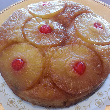 A cake made with caramelized pineapple slices, maraschino cherries 